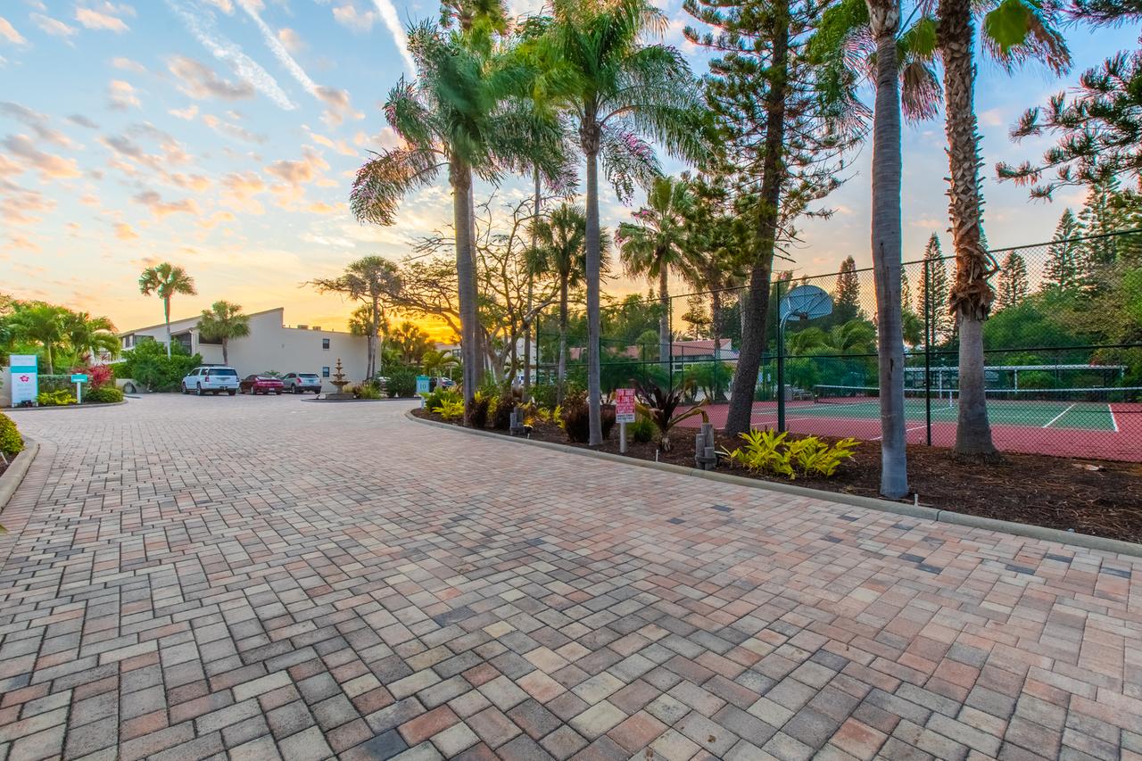 Casa Del Mar resort drive and tennis court beneath palm trees at sunset