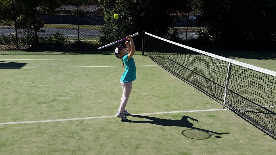 Child hitting a tennis ball on the court