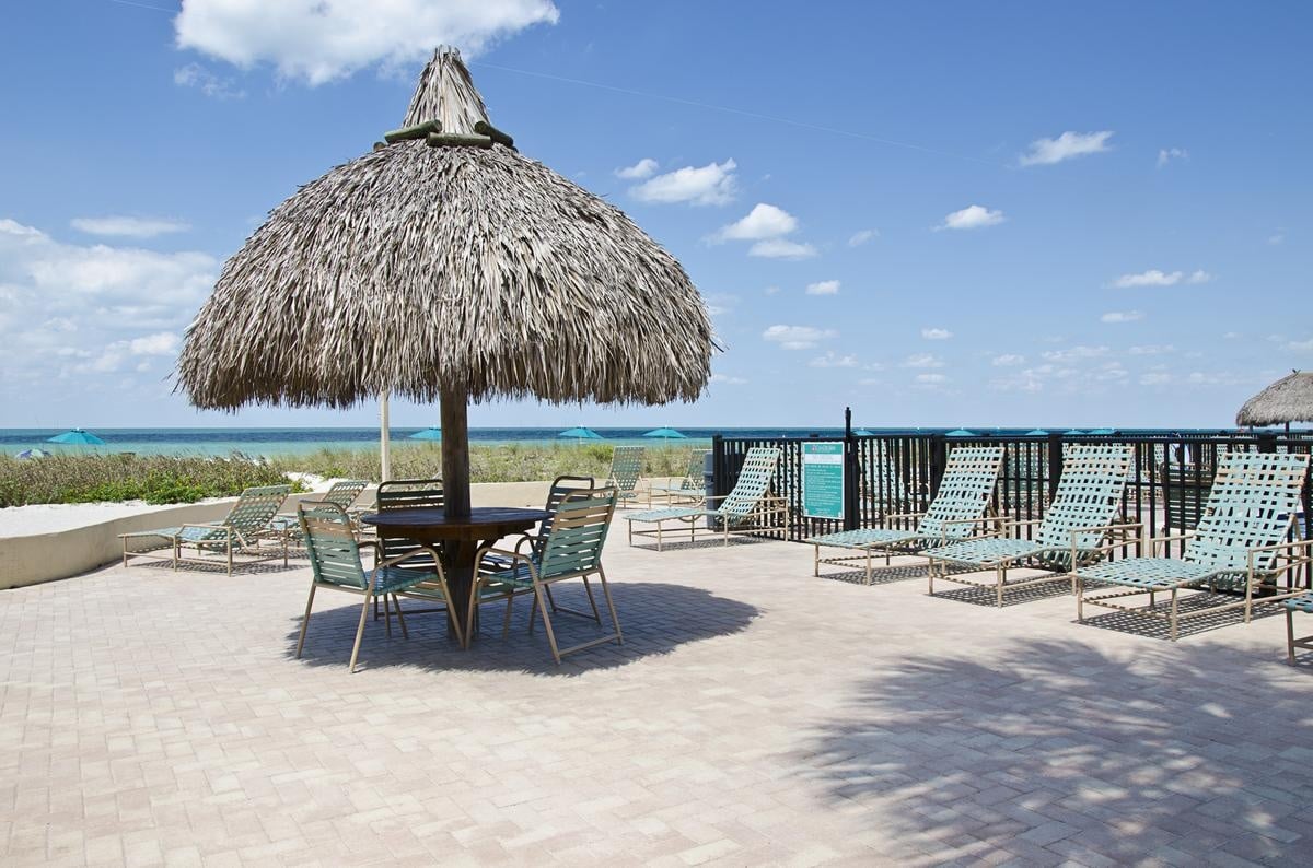 Thatched beach cabana and lounge chairs at Casa Del Mar