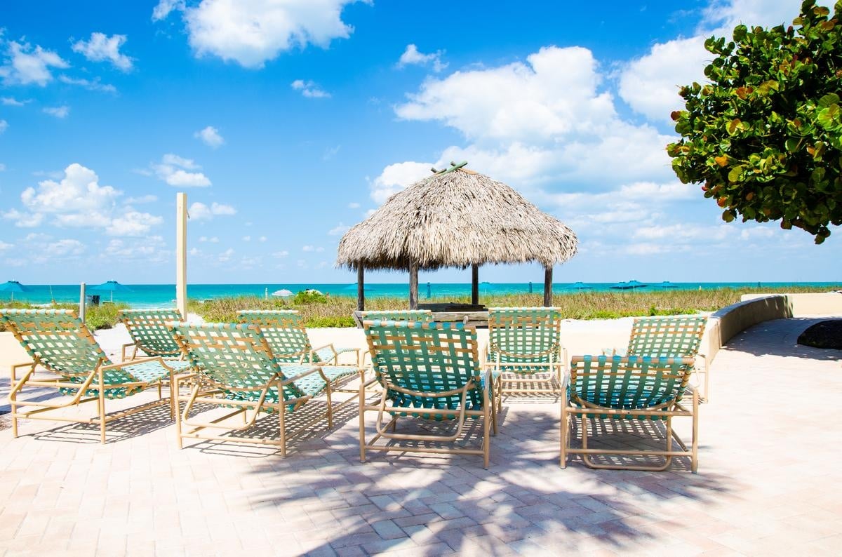 Covered tables and chairs overlooking the beach at Casa Del Mar