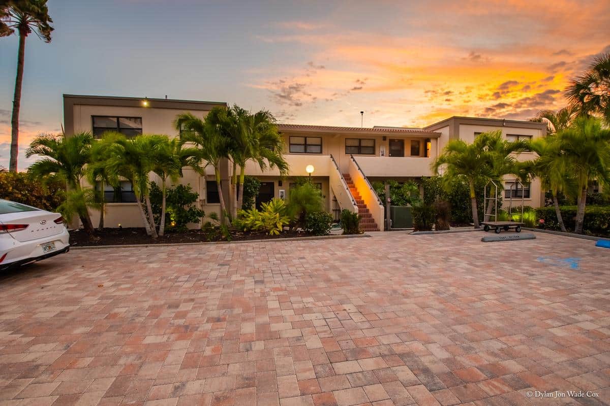 Casa Del Mar resort buildings and palm trees beneath a sunset sky